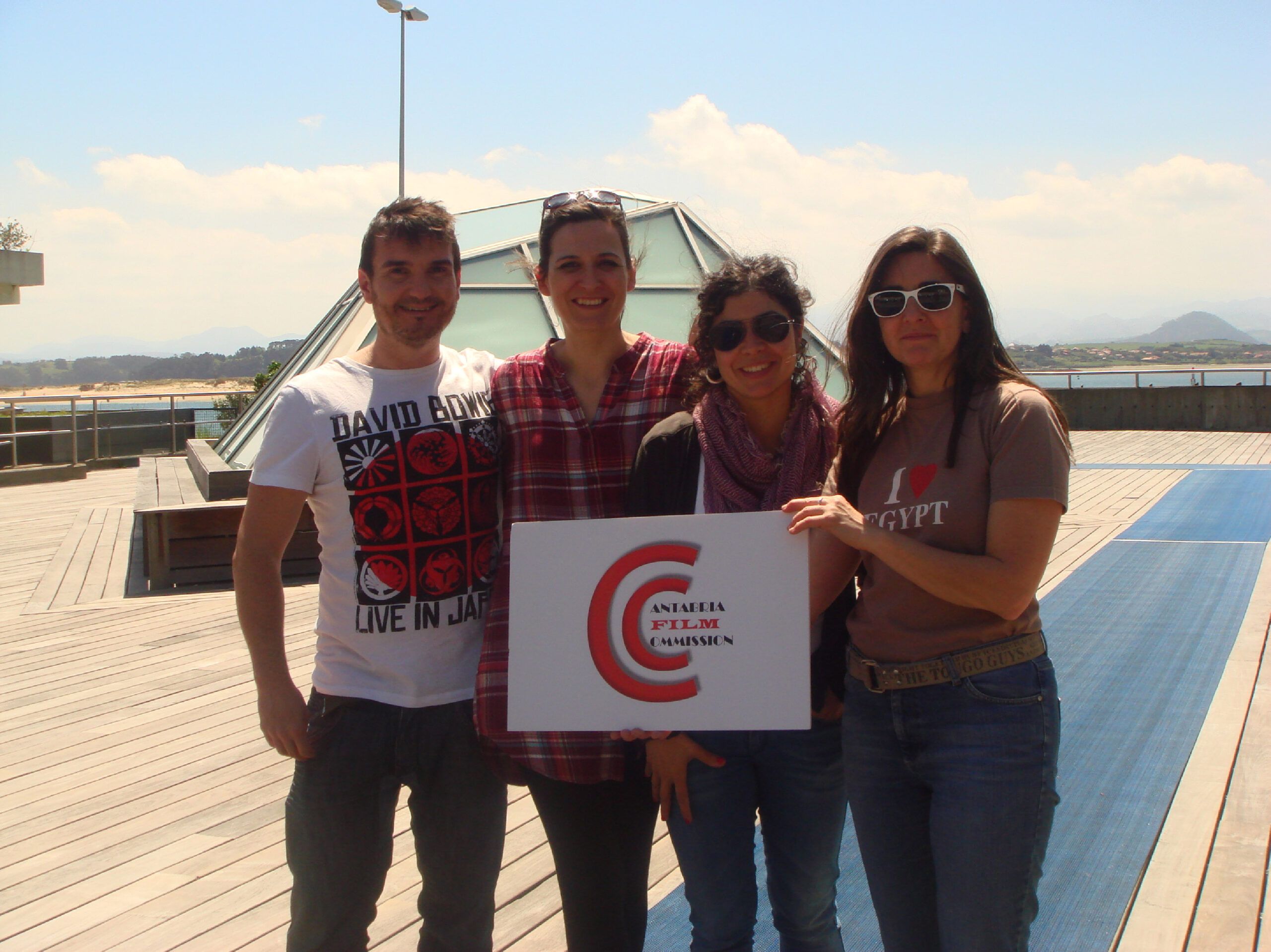 Tres mujeres y un hombre posan con el cartel de cantabria film commission